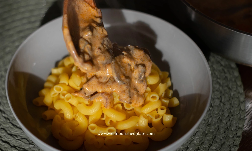 serving gluten free pasta in a plate, with creamy mushroom sauce on top