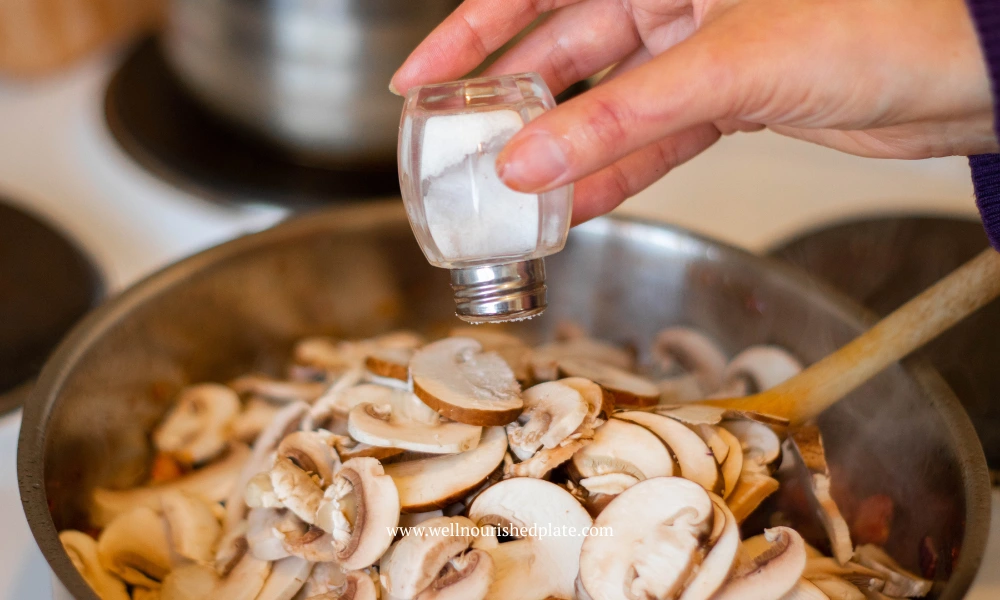 salting the mushrooms in a pan for the creamy gluten free pasta