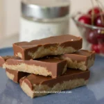 Healthy peanut butter oatmeal bars on a plate next to cherries