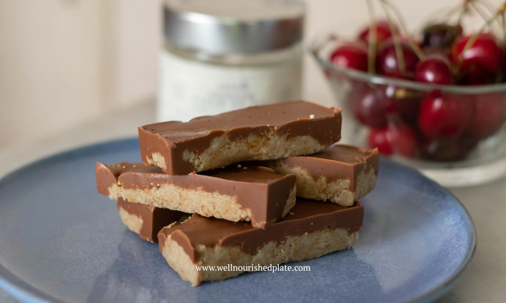 Healthy peanut butter oatmeal bars on a plate next to cherries