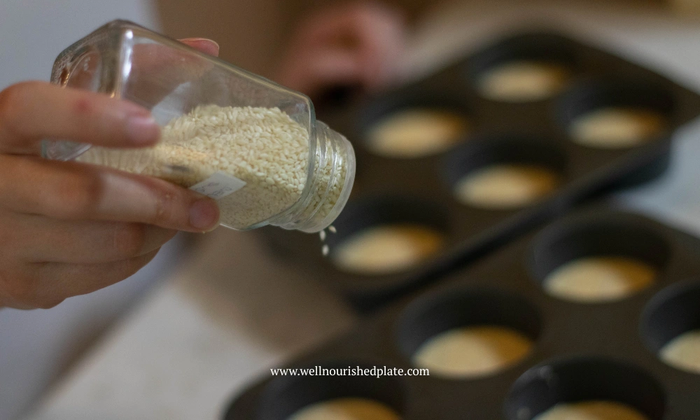 sprinkling sesame seeds over delicious and gluten free savory muffins