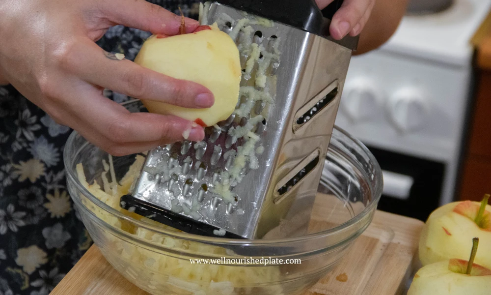 grating the apples for an apple pie